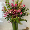 Tall mixed bouquet of pink roses and lilies in a glass vase