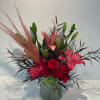 Red roses and pink lilies arranged in a glass vase