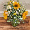 Sunflowers and white daisies arranged in a glass vase