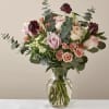 Mixed bouquet of pink and cream roses in a clear glass vase