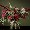 Red and pink floral arrangement in a clear glass vase