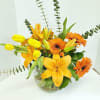 Yellow and orange flower arrangement in a clear glass vase