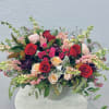 Mixed bouquet of red and blush roses in a clear vase