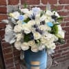 White rose bouquet in a blue hatbox with baby-themed picks