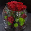 Red roses and green pom-pom flowers in a clear glass bowl