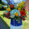 Colorful mixed bouquet in a blue container outdoors