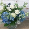 Blue and white flower arrangement in a clear glass vase