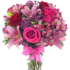Pink and red bouquet of roses and lilies in a glass vase with a ribbon