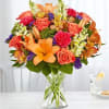 Orange and coral bouquet in a clear glass vase