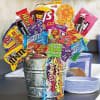 Bucket filled with assorted candy bags and curly ribbon streamers