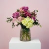 Pink and purple flower arrangement in a glass vase