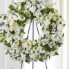 White floral wreath on a black stand