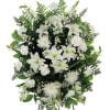 A classic white floral sympathy standing spray, with white carnations, white mums