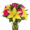 Bouquet of pink roses and yellow lilies in a clear glass vase