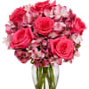 Pink roses and alstroemeria arranged in a clear glass vase