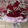 Bouquet of red roses with white baby's breath in pink wrapping