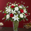 Red roses and white lilies in a clear glass vase