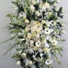 Large white funeral spray with roses, lilies, and gerbera daisies