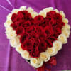Heart-shaped bouquet of red and white roses with a red ribbon