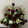 Red roses and white lilies arranged in a tall display with gold fan accents