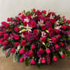 Large arrangement of pink roses, lilies, and purple flowers
