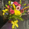 Colorful mixed bouquet in a glass vase with a yellow polka-dot ribbon