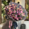 Large bouquet of pink and lavender flowers wrapped in mauve paper