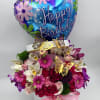 Birthday balloon above a pink and purple flower arrangement in a white box