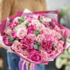Pink bouquet of roses and carnations wrapped in magenta paper