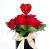 Red roses in a black vase with a gold ribbon and glitter heart pick