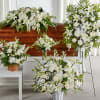 White floral funeral arrangements around a casket