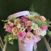 Pink and peach roses arranged in a pale pink hatbox