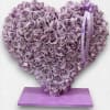 Arrangement is made out of wood base. Filled with purple roses reflexed