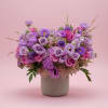 Purple and pink flower arrangement in a gray vase