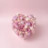Heart-shaped bouquet of pink and white roses on a pink background