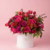 Pink roses and tulips arranged in a white hat box