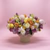 Mixed bouquet of pastel roses and ranunculus in a round vase