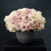 Pink and white roses arranged in a dark vase