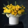 Yellow roses and white hydrangeas in a white vase