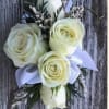 White rose boutonniere with ribbon on a wood background