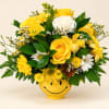 Yellow and white mixed bouquet in a smiley-face vase