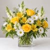 Yellow roses and white daisies in a clear glass vase