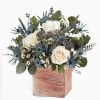 White roses and blue thistle in a pink wooden box