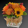 Bright mixed bouquet with a sunflower in a glass vase