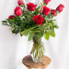 Red roses arranged in a clear glass vase