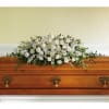White floral spray arranged on a wooden casket