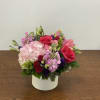 Pink and red flower arrangement in a white box vase