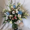 Mixed bouquet in a glass vase with blue, white, and pink flowers