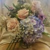 Bouquet of pale pink roses and lavender hydrangea in a glass vase