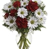 Red carnations and white daisies in a clear glass vase